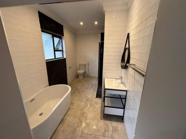 Black and white luxury bathroom with bath, shower, toilet and basin Aksium Projects