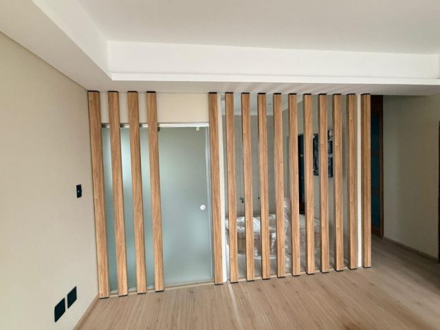 Bedroom leading to bathroom with wood screen Aksium Projects