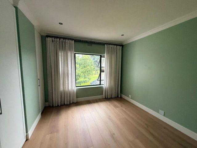 Bedroom with green paint and curtains Aksium Projects
