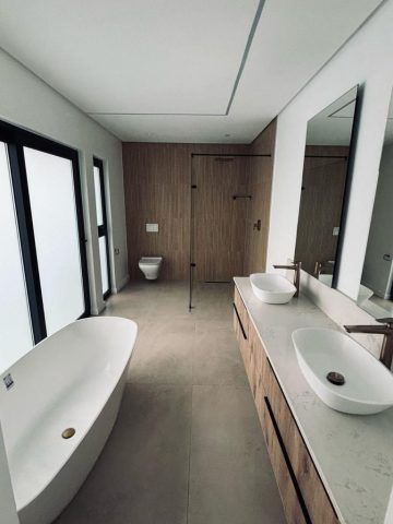 Main bathroom with bath, shower, toilet and double basins Aksium Projects