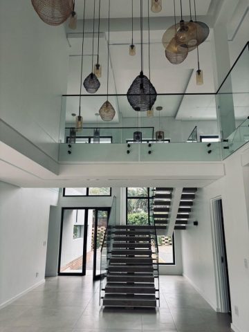 Luxury entrance with glass features and hanging lights Aksium Projects