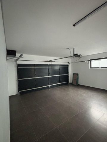 Double garage with floor tiles Aksium Projects