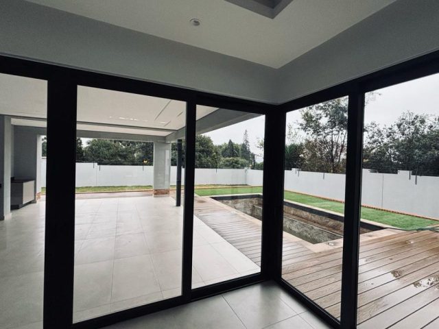 Entertainment area leading to a pool and garden Aksium Projects